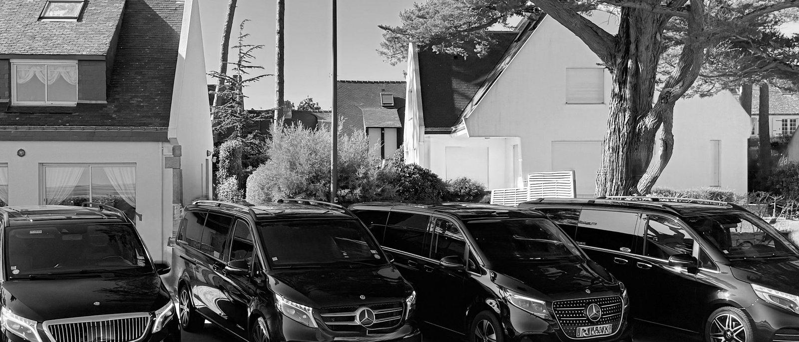 Fleet of Mercedes vans with private chauffeur parked on a residential street in Vannes